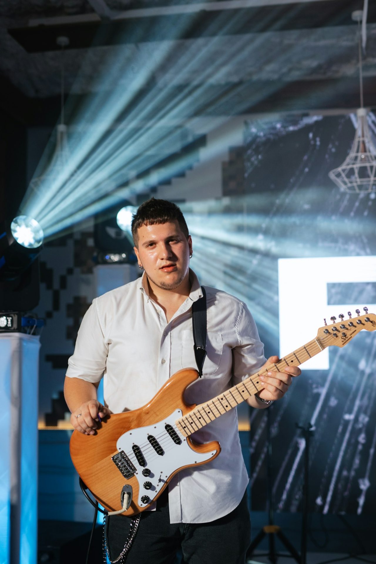 guy musician plays the electric guitar at a concert